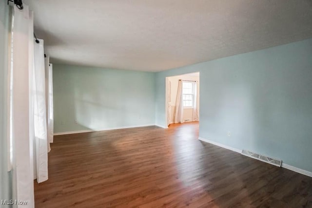 spare room with dark hardwood / wood-style floors