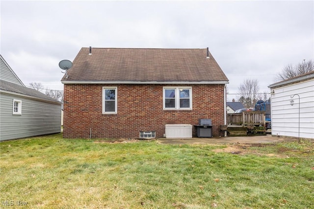 rear view of property with a lawn and a patio