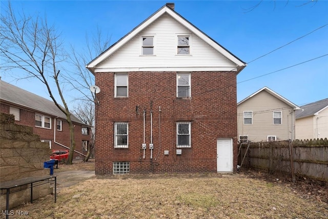 rear view of property featuring a lawn