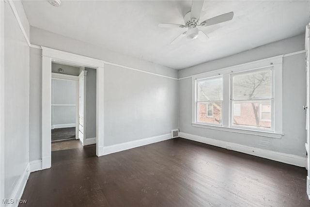 unfurnished room featuring dark wood-type flooring and ceiling fan