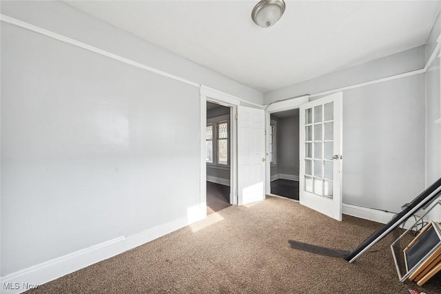 carpeted spare room featuring french doors