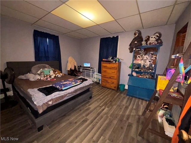 bedroom with a drop ceiling and hardwood / wood-style floors