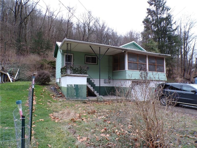 view of front of house featuring a front lawn and a sunroom