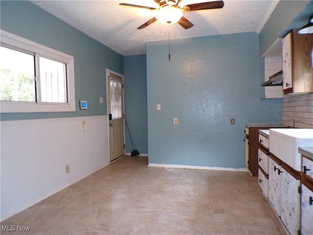 kitchen featuring ceiling fan and a textured ceiling