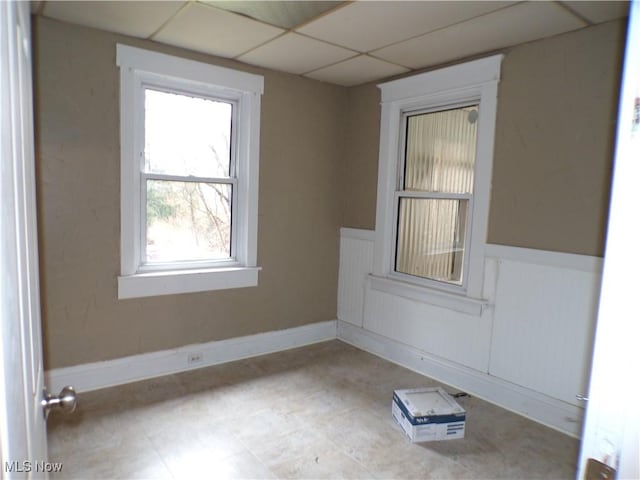 unfurnished room featuring a drop ceiling