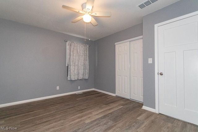 unfurnished bedroom featuring ceiling fan, dark hardwood / wood-style floors, and a closet