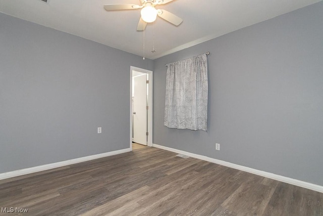 empty room with dark wood-type flooring and ceiling fan