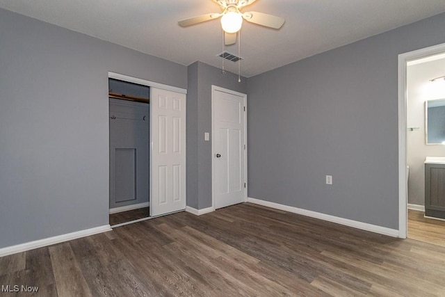 unfurnished bedroom with ceiling fan, connected bathroom, dark hardwood / wood-style flooring, and a closet