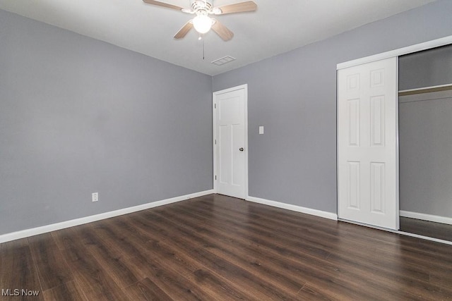 unfurnished bedroom with ceiling fan, dark hardwood / wood-style flooring, and a closet