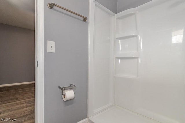 bathroom with hardwood / wood-style flooring and a shower