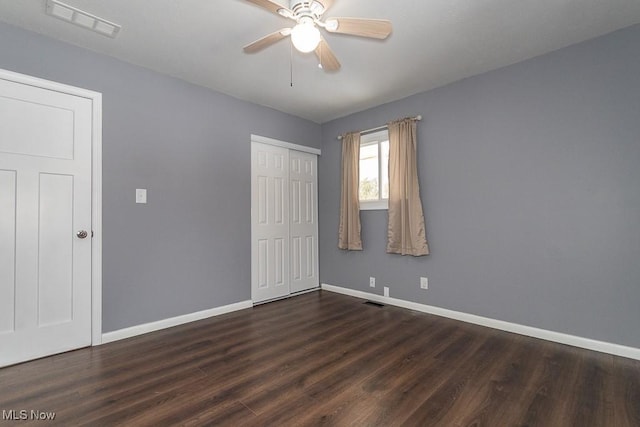 unfurnished bedroom with dark wood-type flooring, ceiling fan, and a closet