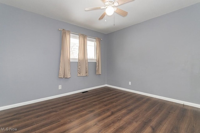 empty room featuring dark wood-type flooring and ceiling fan