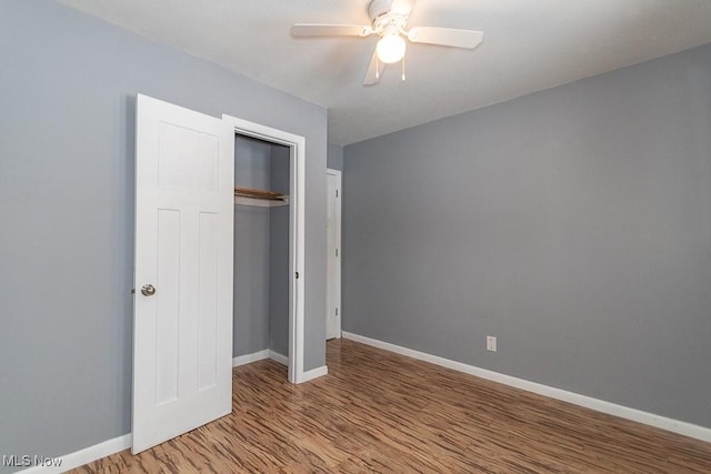 unfurnished bedroom with ceiling fan, a closet, and light wood-type flooring