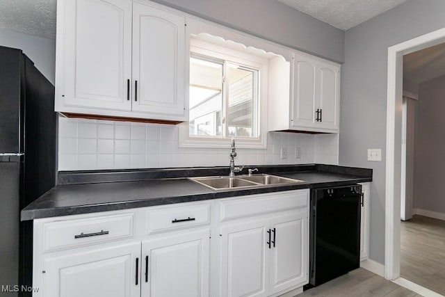 kitchen featuring backsplash, white cabinets, sink, and black appliances