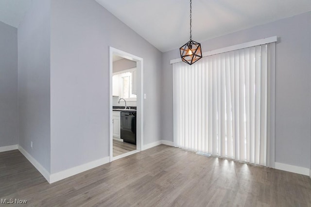 unfurnished room with wood-type flooring, lofted ceiling, and a wealth of natural light