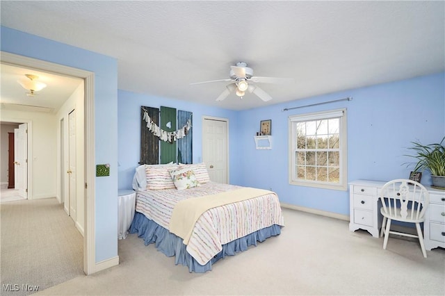 bedroom featuring light colored carpet, a closet, and ceiling fan