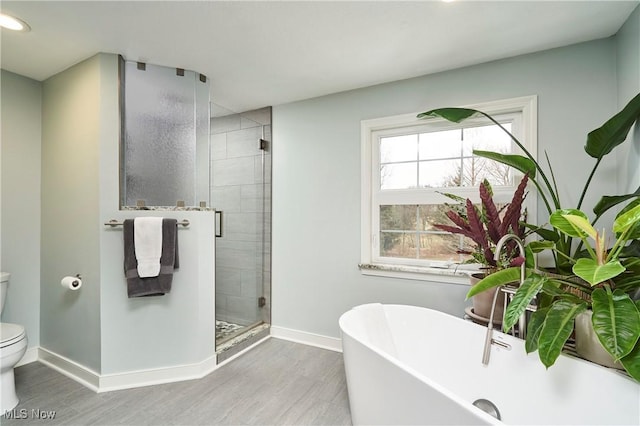 bathroom featuring hardwood / wood-style flooring, shower with separate bathtub, and toilet