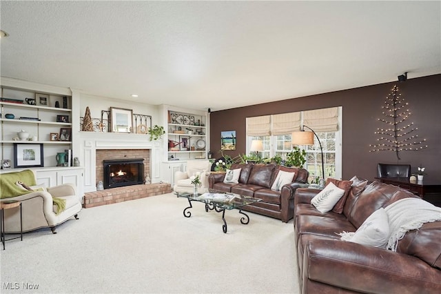 living room with built in features, carpet flooring, a brick fireplace, and a textured ceiling