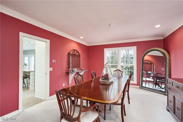 dining room with crown molding and light carpet