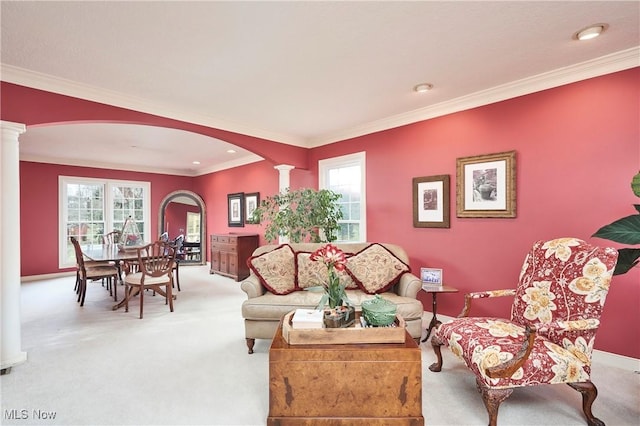 living room with light colored carpet, a wealth of natural light, and decorative columns