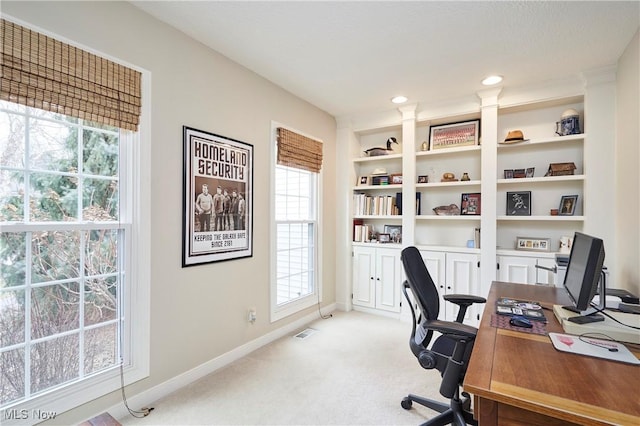 home office featuring light carpet and built in features