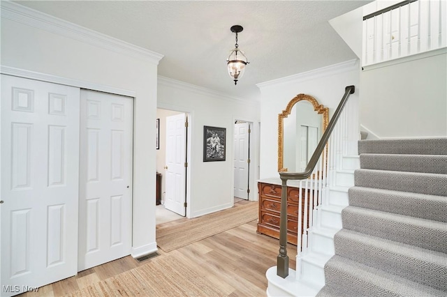 staircase featuring hardwood / wood-style flooring and ornamental molding