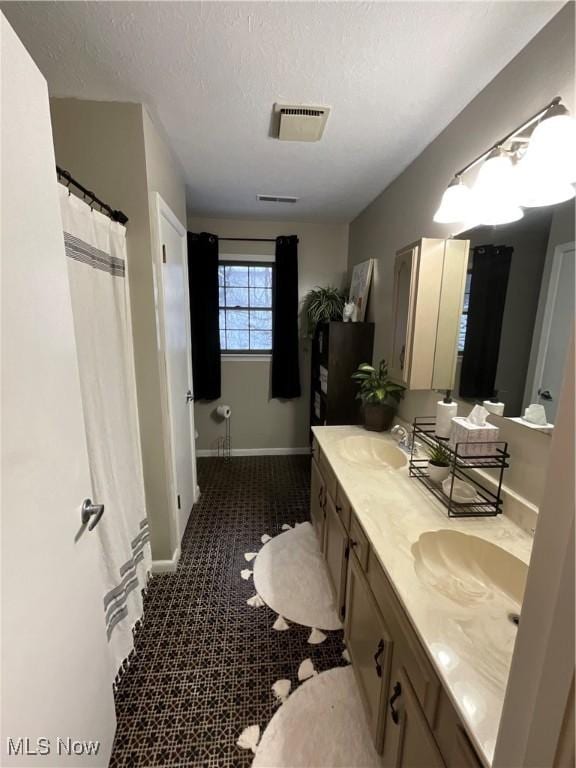 bathroom with a shower with curtain, vanity, and a textured ceiling