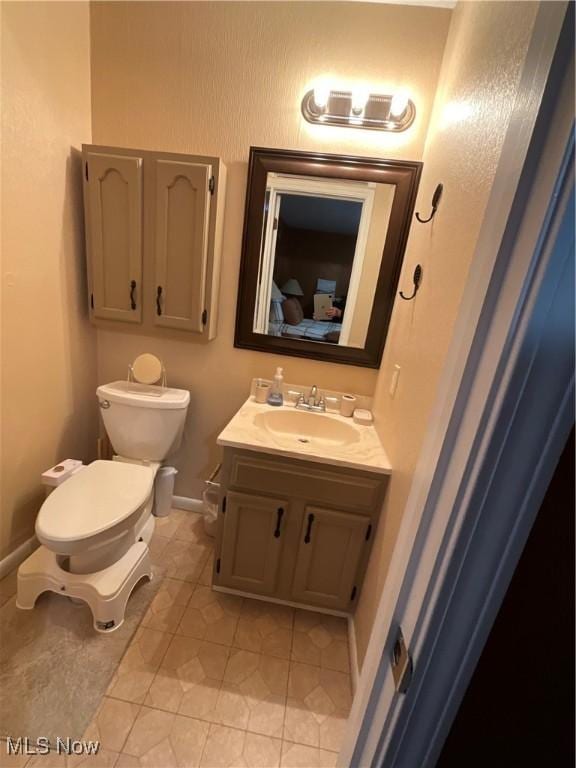 bathroom with vanity, tile patterned floors, and toilet