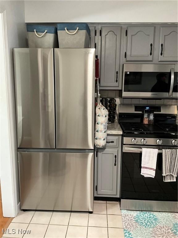 kitchen with light tile patterned flooring, stainless steel appliances, and gray cabinets