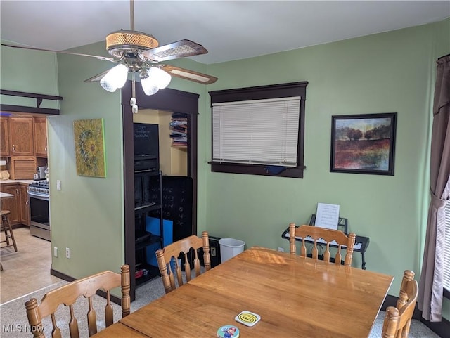 dining area featuring ceiling fan and light colored carpet