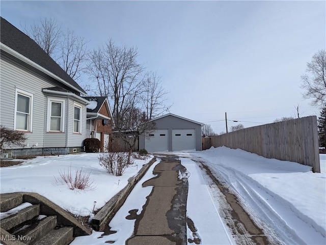 snowy yard with an outbuilding and a garage