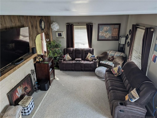 carpeted living room with a large fireplace