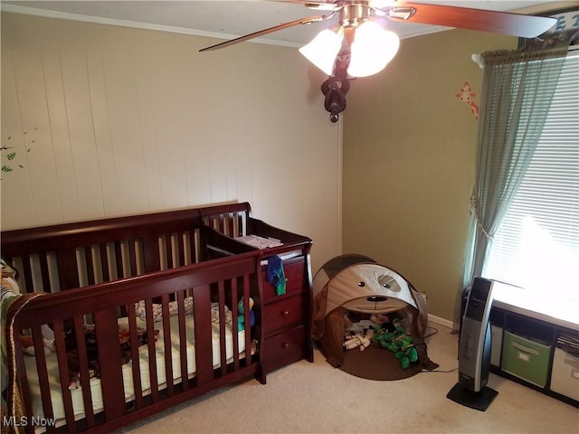 carpeted bedroom with ornamental molding and ceiling fan