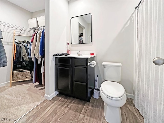 bathroom featuring vanity, toilet, and hardwood / wood-style floors