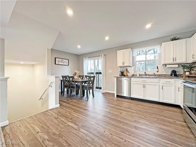 kitchen featuring white cabinetry, light hardwood / wood-style flooring, plenty of natural light, stainless steel appliances, and decorative backsplash