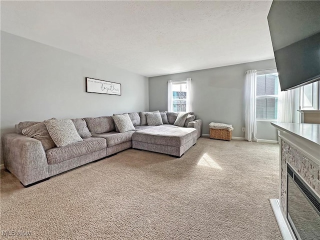 living room featuring light colored carpet, a stone fireplace, and a textured ceiling