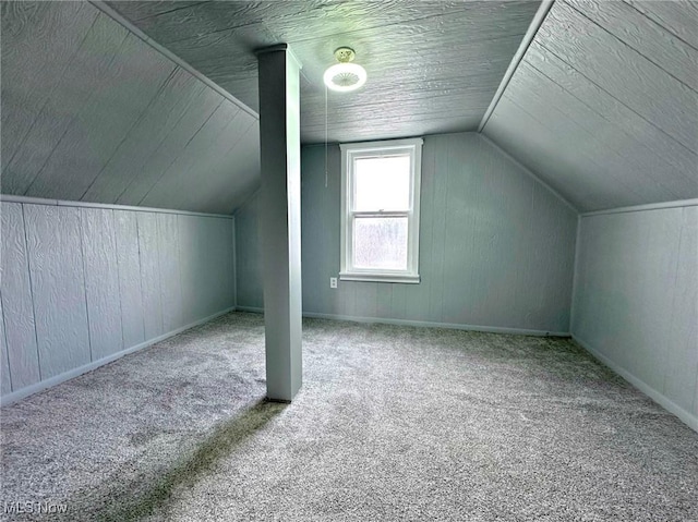 bonus room with vaulted ceiling and carpet