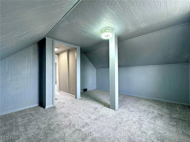 bonus room featuring lofted ceiling, carpet floors, and a textured ceiling