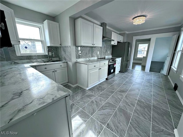 kitchen with sink, white cabinetry, stainless steel appliances, light stone countertops, and wall chimney range hood