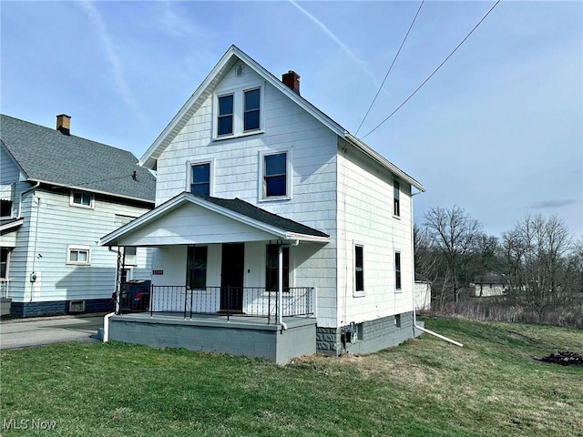 view of front of home featuring covered porch and a front lawn