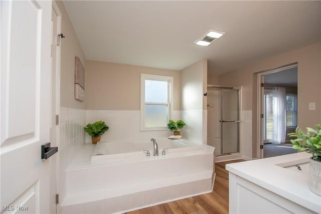 bathroom featuring shower with separate bathtub, hardwood / wood-style floors, and vanity