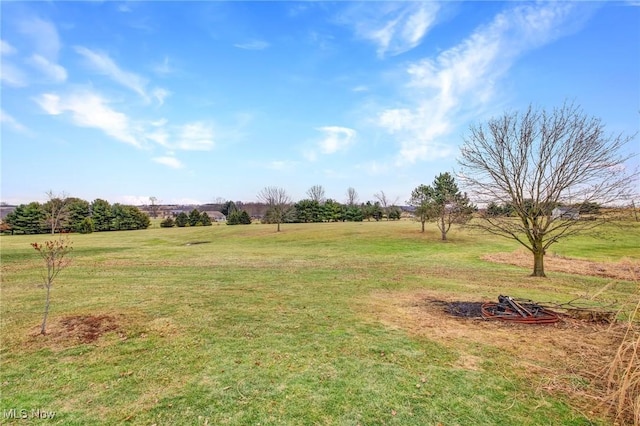 view of yard featuring a rural view and an outdoor fire pit