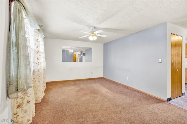 carpeted spare room featuring ceiling fan and a textured ceiling