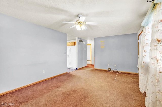 carpeted spare room with ceiling fan and a textured ceiling