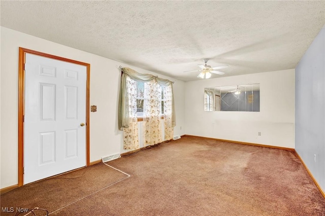 empty room with ceiling fan, carpet floors, and a textured ceiling