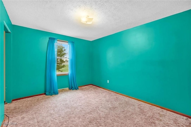 carpeted empty room featuring a textured ceiling