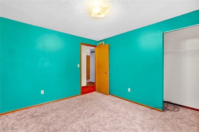 unfurnished bedroom with a closet, a textured ceiling, and carpet flooring