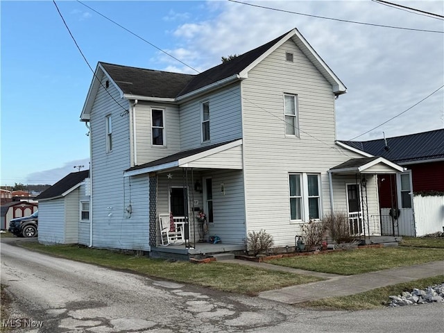 view of front property featuring covered porch and a front lawn