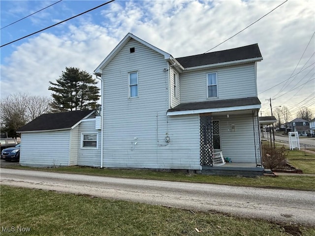 rear view of house with a yard and covered porch