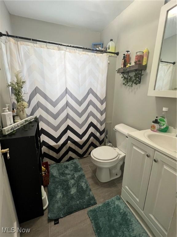 bathroom featuring vanity, a shower with shower curtain, and toilet